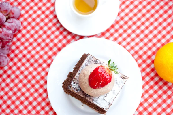 Vacker tårta med jordgubbar, tangerine, grape och te på Pläd — Stockfoto