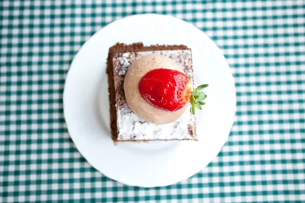 प्लेड फॅब्रिक वर स्ट्रॉबेरीसह सुंदर केक — स्टॉक फोटो, इमेज