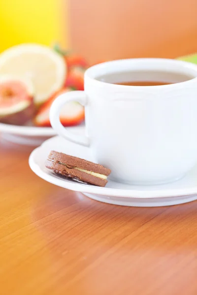 Taza de té, galletas, manzana, limón, higo y fresas en un plato —  Fotos de Stock
