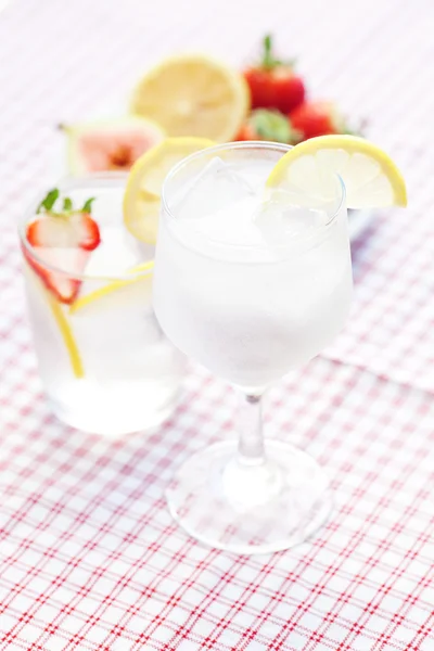 Cocktail with ice,lemon, fig and strawberries on a plate — Stock Photo, Image