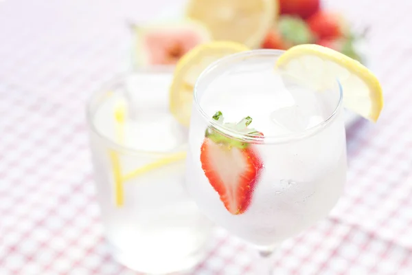 Коктейль со льдом, лимоном, инжиром и клубникой на тарелке — стоковое фото