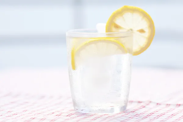 Acqua con limone e lime in un bicchiere con ghiaccio — Foto Stock