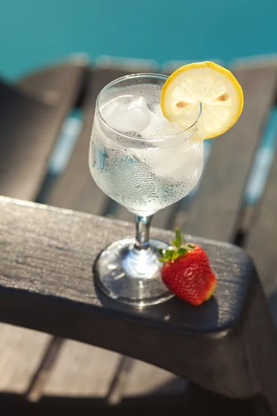 Piscina, salón, una copa de vino con hielo, limón y fresa —  Fotos de Stock