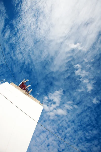 Bakgrunn på blå himmel med skyer og veggen i bygningen – stockfoto