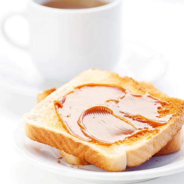 Чай и тост с карамелью изолированы на белом — стоковое фото
