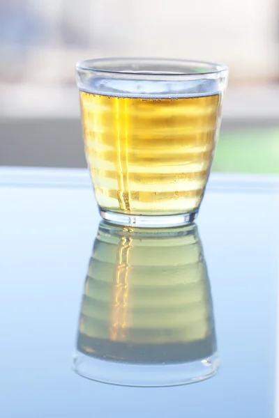 Cerveja em um copo na superfície reflexiva — Fotografia de Stock