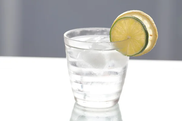 Agua con limón y lima en un vaso con hielo — Foto de Stock