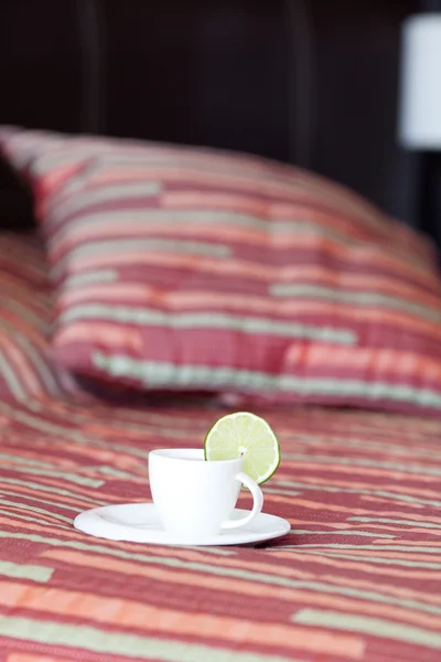 Bed met twee kussens, een kopje thee op de deken — Stockfoto
