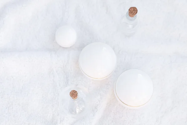 Kozmetik kapları ve şişe üzerinde beyaz bir havlu — Stok fotoğraf