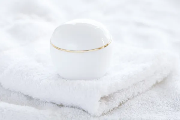 Contenitori cosmetici sdraiati su un asciugamano bianco — Foto Stock