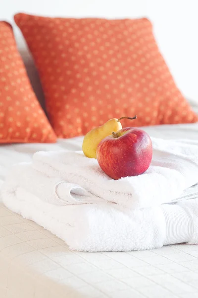 Яблоко и груша лежат на кровати — стоковое фото