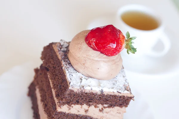 Belo bolo com morango e chá em um fundo branco — Fotografia de Stock