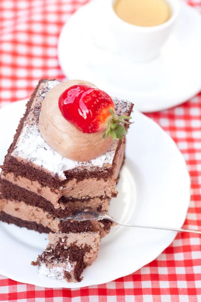 Schöner Kuchen mit Erdbeere und Tee auf kariertem Stoff — Stockfoto