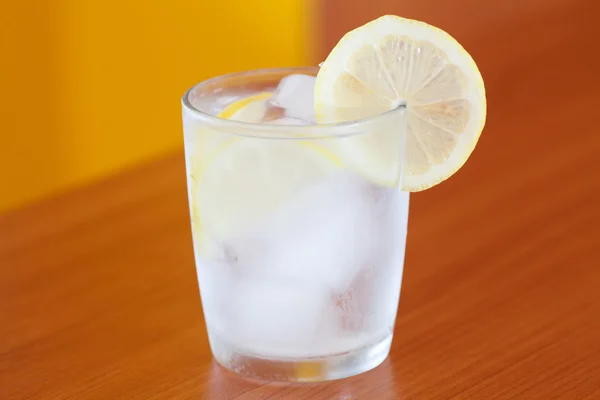 Вода со льдом и лимоном на столе — стоковое фото