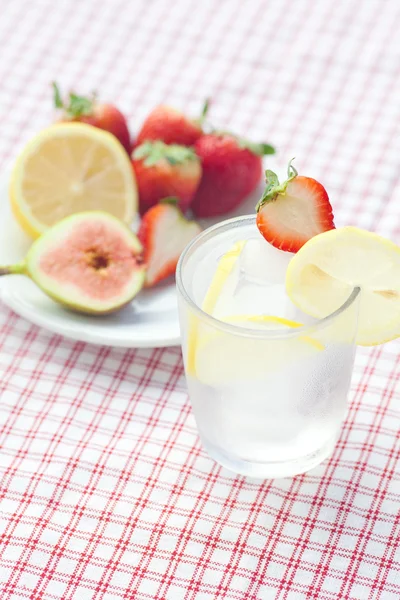 Cóctel con hielo, limón, higo y fresas en un plato —  Fotos de Stock