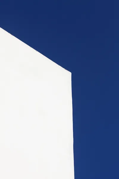 Белая стена здания на фоне голубого неба — стоковое фото