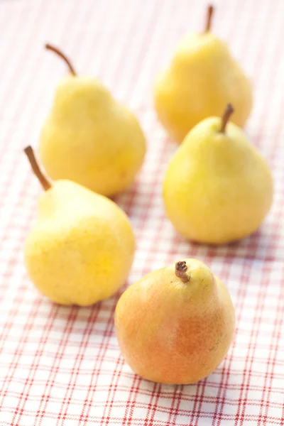 Pears lying on a plaid fabric — Stock Photo, Image