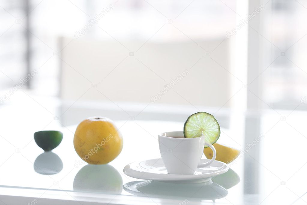 Cup of tea with tropical fruits on a glass surface