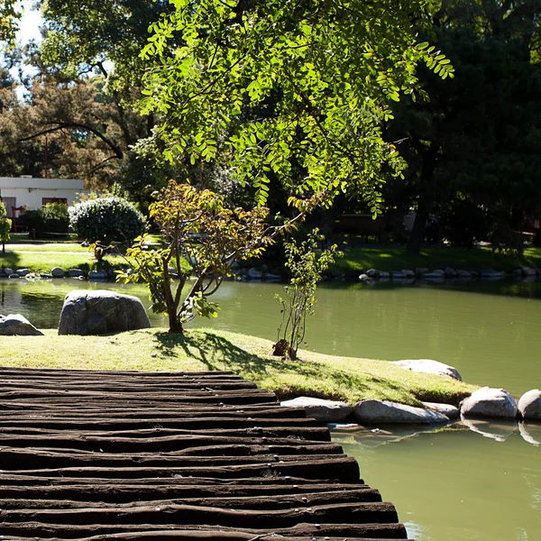 Дерев'яний міст з ставком в парку — стокове фото