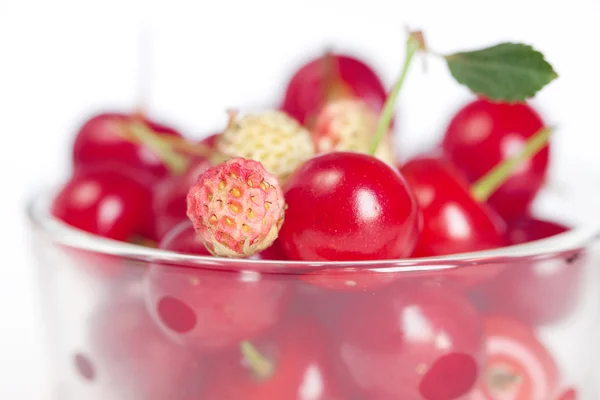 Copa de vidrio con cerezas y fresas silvestres en un fondo blanco —  Fotos de Stock