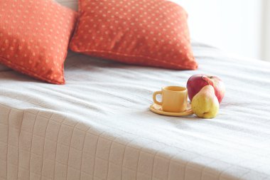 Cup of tea,apple and pear on the bed clipart