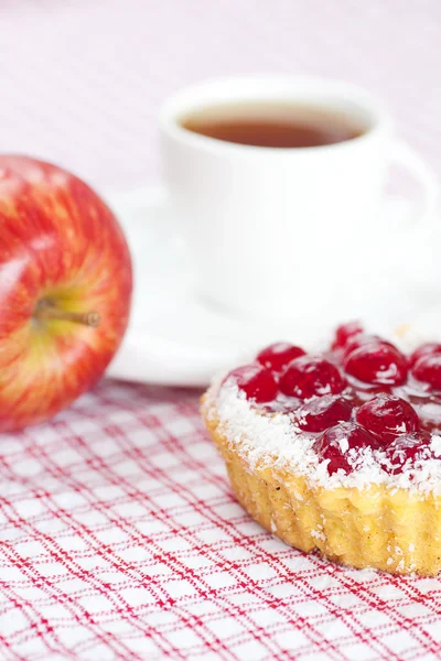Elma, çilek ve çay ekose kumaş üzerine ile güzel pasta — Stok fotoğraf