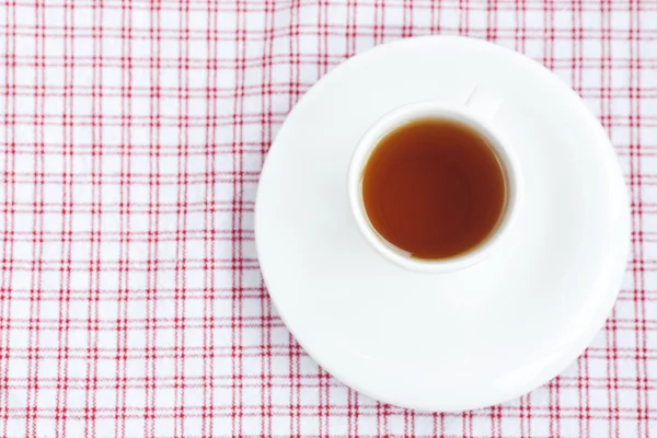 Чашка чая на клетчатой ткани — стоковое фото