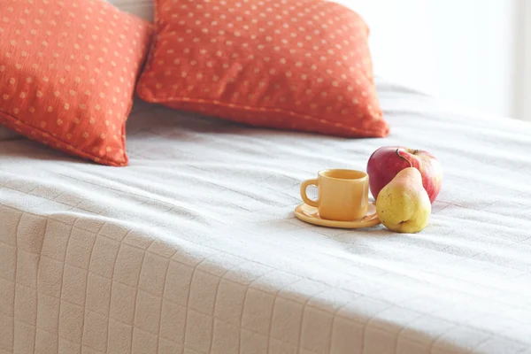 Xícara de chá, maçã e pêra na cama — Fotografia de Stock