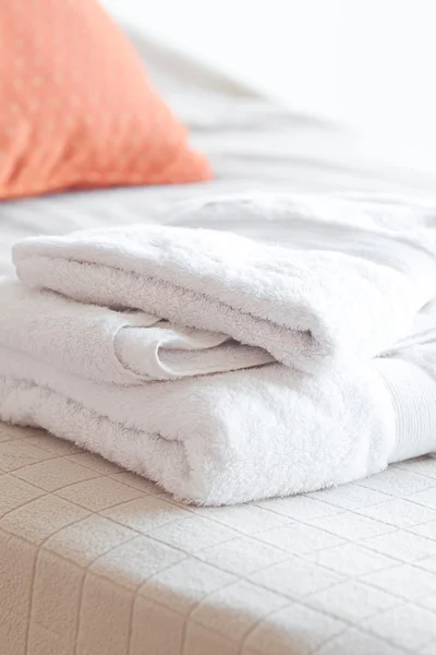 Белые полотенца лежат на кровати — стоковое фото