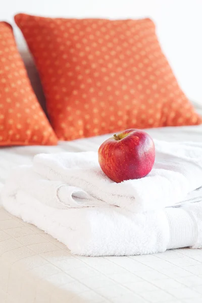 Maçã e toalhas brancas na cama — Fotografia de Stock