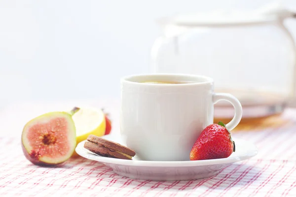 Tasse Tee, Kekse, Feigen und Erdbeeren auf einem Teller — Stockfoto
