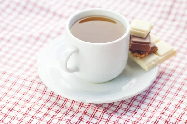 Bar of chocolate and tea on plaid fabric — Stock Photo, Image