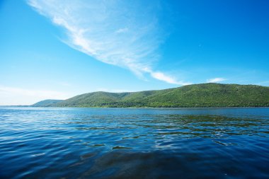 Mountain with trees against the blue sky and the river clipart