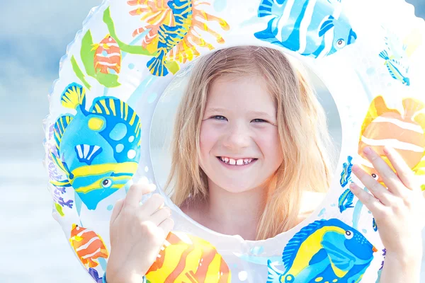 Porträt eines schönen kleinen Mädchens mit einem farbigen Rettungsring — Stockfoto