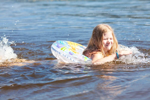 Beautiful little girl floating in the water — Stock Photo, Image