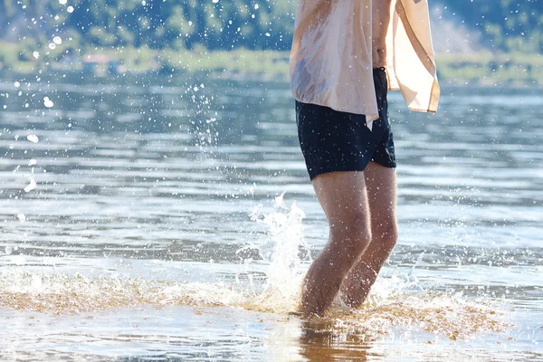 Benen van de man springen in het water — Stockfoto