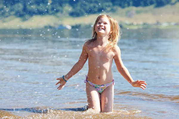 Linda menina espirra na água — Fotografia de Stock