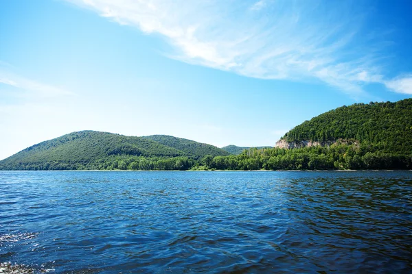 Mountain with trees against the blue sky and the river — Stock Photo, Image