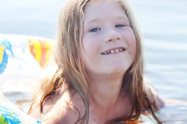 Porträtt av en vacker liten flicka med en färg livboj — Stockfoto