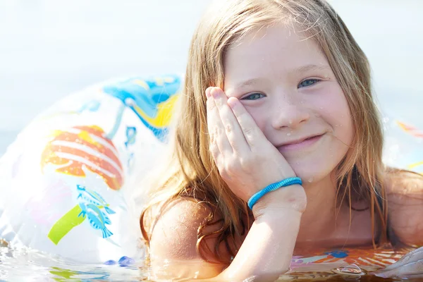 Porträt eines schönen kleinen Mädchens mit einem farbigen Rettungsring — Stockfoto