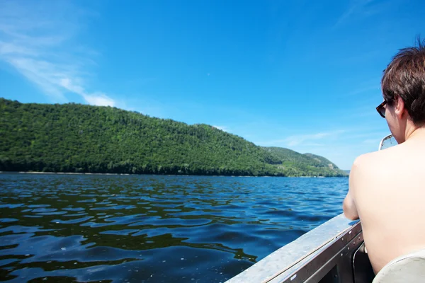 Hombre en un barco en el fondo del río y las montañas — Foto de Stock