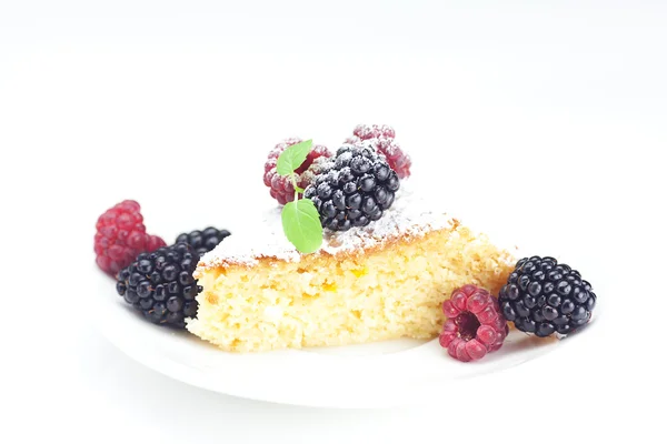 Cake with icing, raspberry, blackberry and mint on a plate on a — Stock Photo, Image