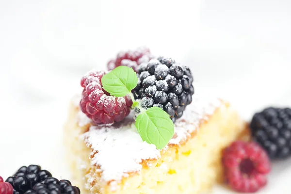Kuchen mit Zuckerguss, Himbeere, Brombeere und Minze auf weißem Rücken — Stockfoto