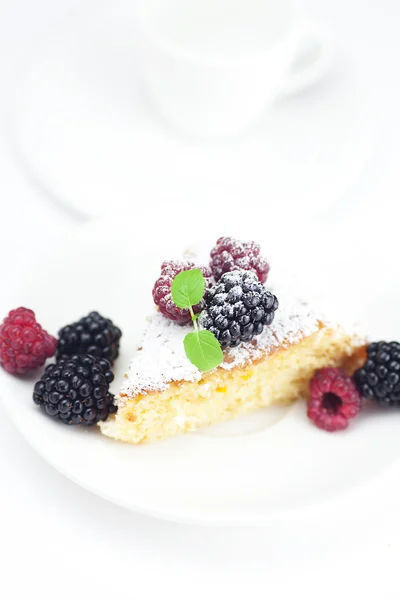 Tasse, Kuchen, Himbeere, Brombeere und Minze auf einem Teller auf einem weißen — Stockfoto