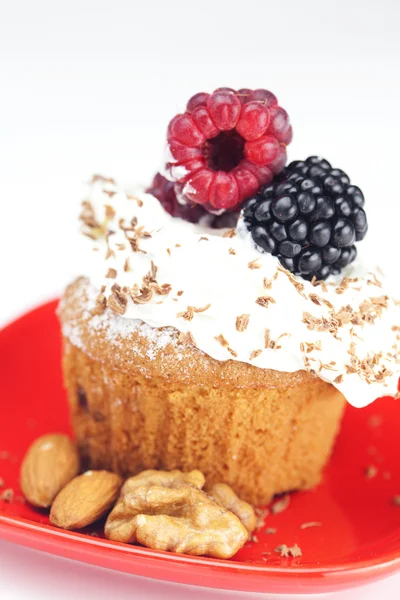 Muffin with whipped cream, raspberries, blackberries and nuts — Stock Photo, Image