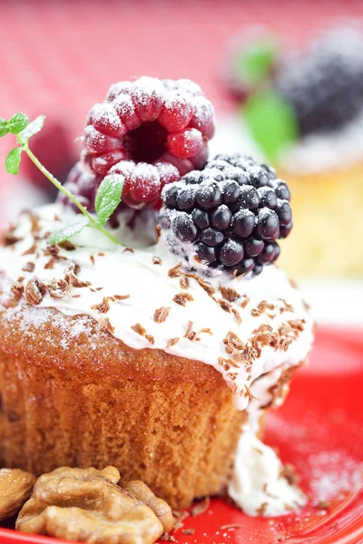 Muffin with whipped cream, cake with icing, raspberry, blackberr — Stock Photo, Image