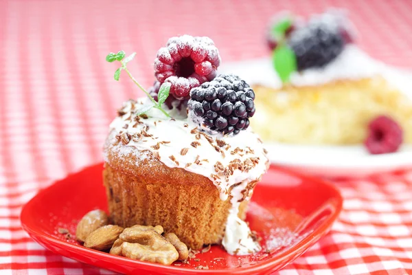 Muffin con crema batida, pastel con glaseado, frambuesa, blackberr —  Fotos de Stock