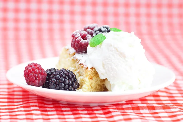 Pastel con glaseado, helado, frambuesa, mora y menta en una pl —  Fotos de Stock