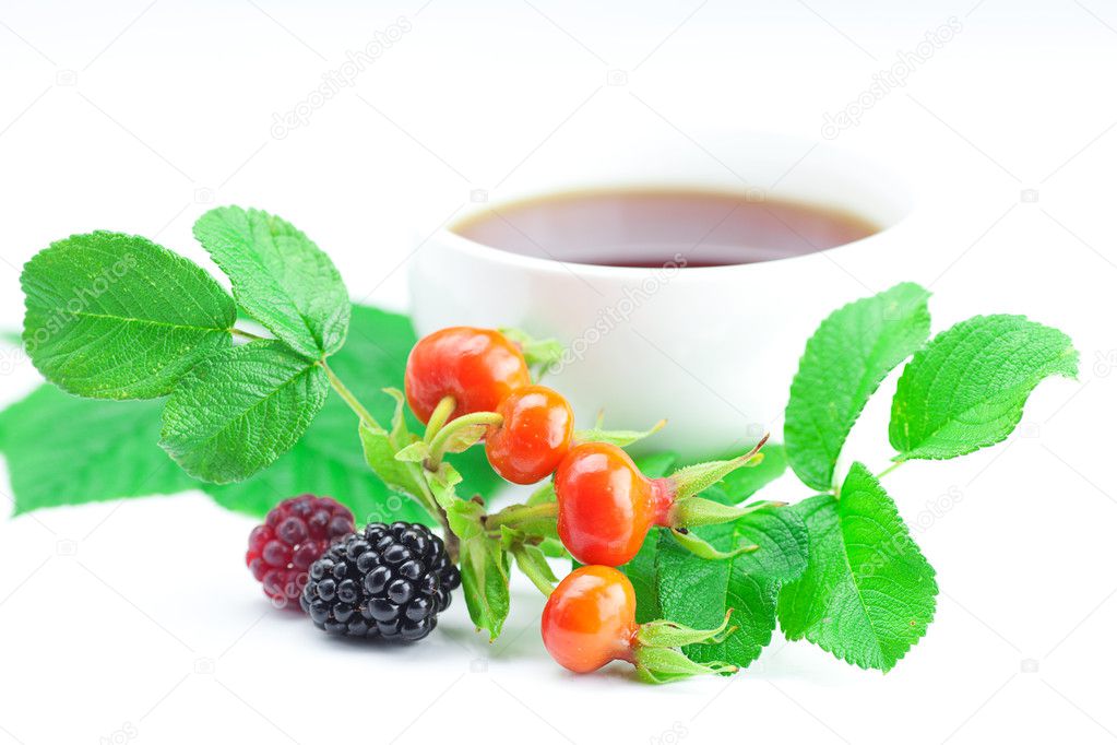 Cup of tea, blackberry,raspberry and rosehip berries with leaves