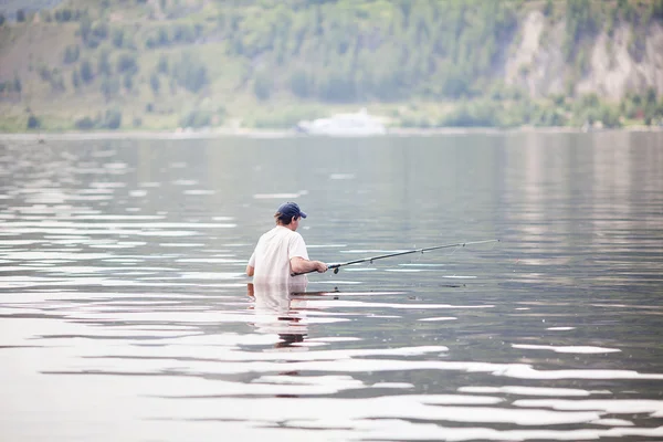 Mladý muž rybaří v řece — Stock fotografie